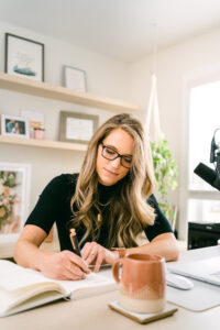 Image of Business Coach Laura Schoenfeld writing used for blog about content strategy for health coach business