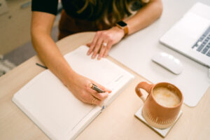 Business Coach Laura journaling photo used in blog about if I should I raise my prices
